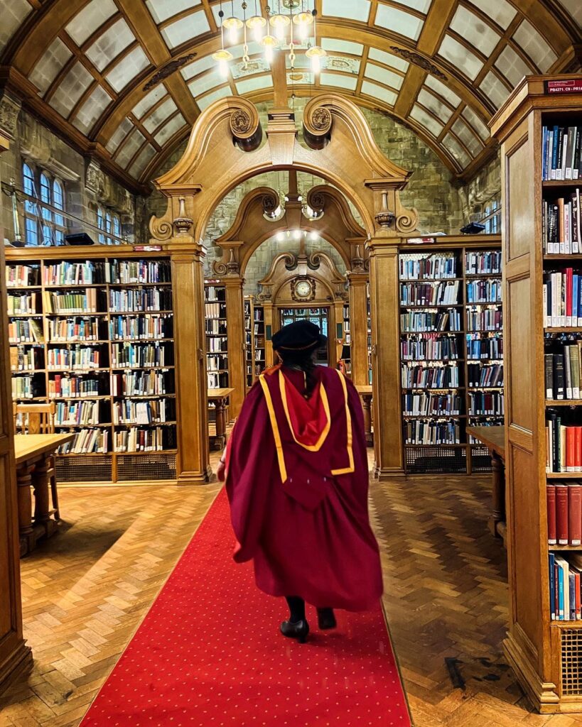 Bangor PhD Graduate in library walking away
